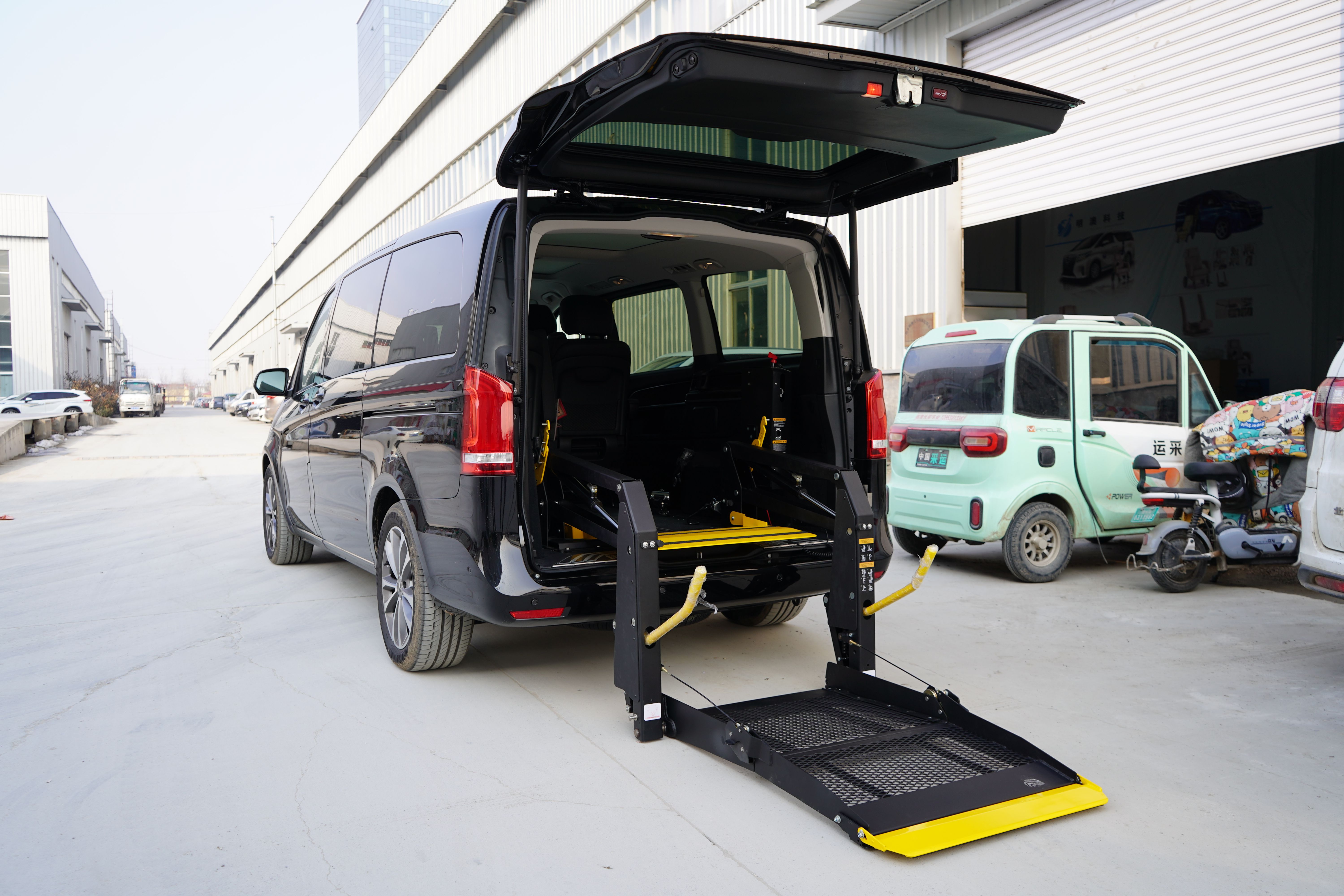 Professional driver assisting wheelchair patient into accessible van